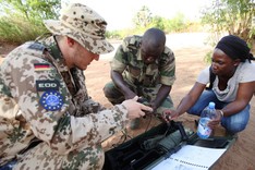 a German EUTM Mali soldier, supported by an interpreter, teaches a Malian soldier in explosive ordnance disposal