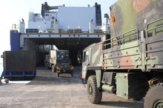 Lkws der Bundeswehr fahren auf ein Fährschiff.