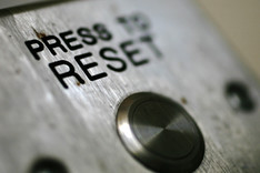 Nahaufnahme eines Schaltknopfes auf einem Metallgehäuse, Beschriftung "Press to Reset".