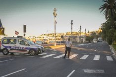 Die Hauptstraße „Promenade des Anglais“ vor der Strandpromenade in Nizza, abgesperrt von einem Polizeiwagen und Polizisten